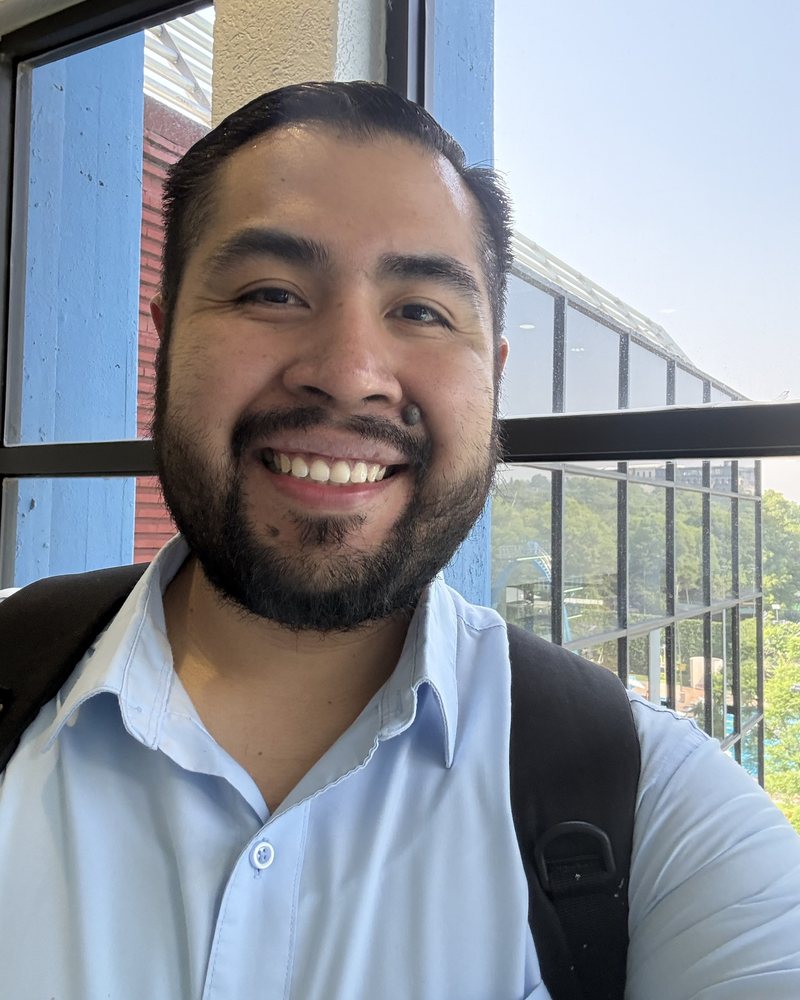 Luis Cerón sonriendo, con camisa azul claro